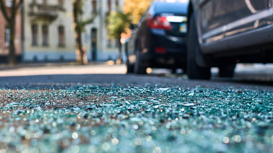Broken glass by parked vehicle